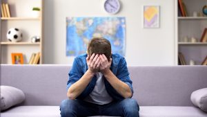 Teen sits with his hands over his face in sadness after experiencing the challenge of autism and trauma in California. He gets autism therapy at Open Doors Therapy with a trauma-informed autism therapist 94306