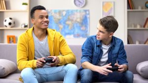 Two men with autism playing video games together. They met in online group autism therapy in California to learn cope with autism and trauma at Open Doors Therapy 94306