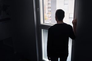 silhouette of a man looking out the window representing depression and anxiety. Learn about autism and comparisons from an autism therapist who offers online autism therapy in California at Open Doors Therapy
